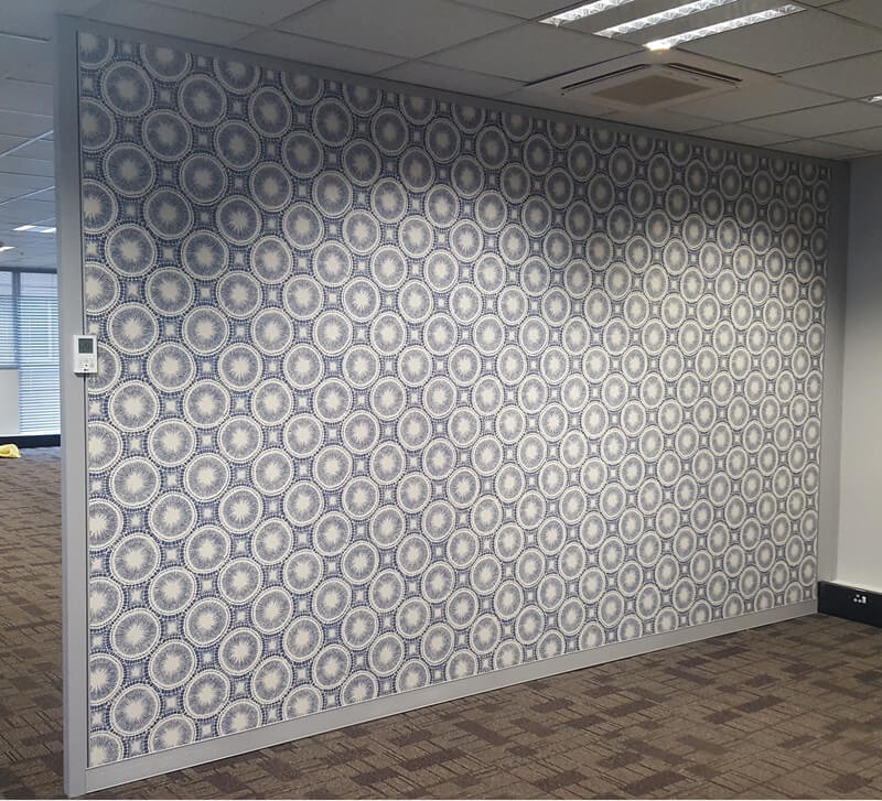 A Cliplok 54 office partition wall featuring a patterned blue and white panel, adding a decorative element to a modern workspace.
