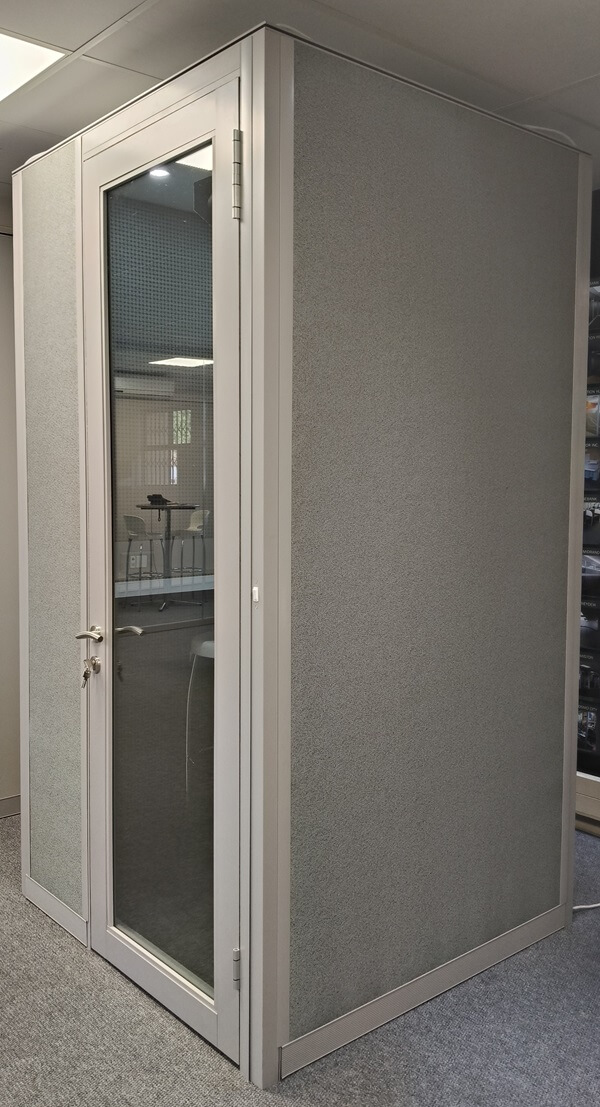 A PRIVA-C54 POD with a glass door, shown in an office setting, offering a quiet and enclosed space for focused work.