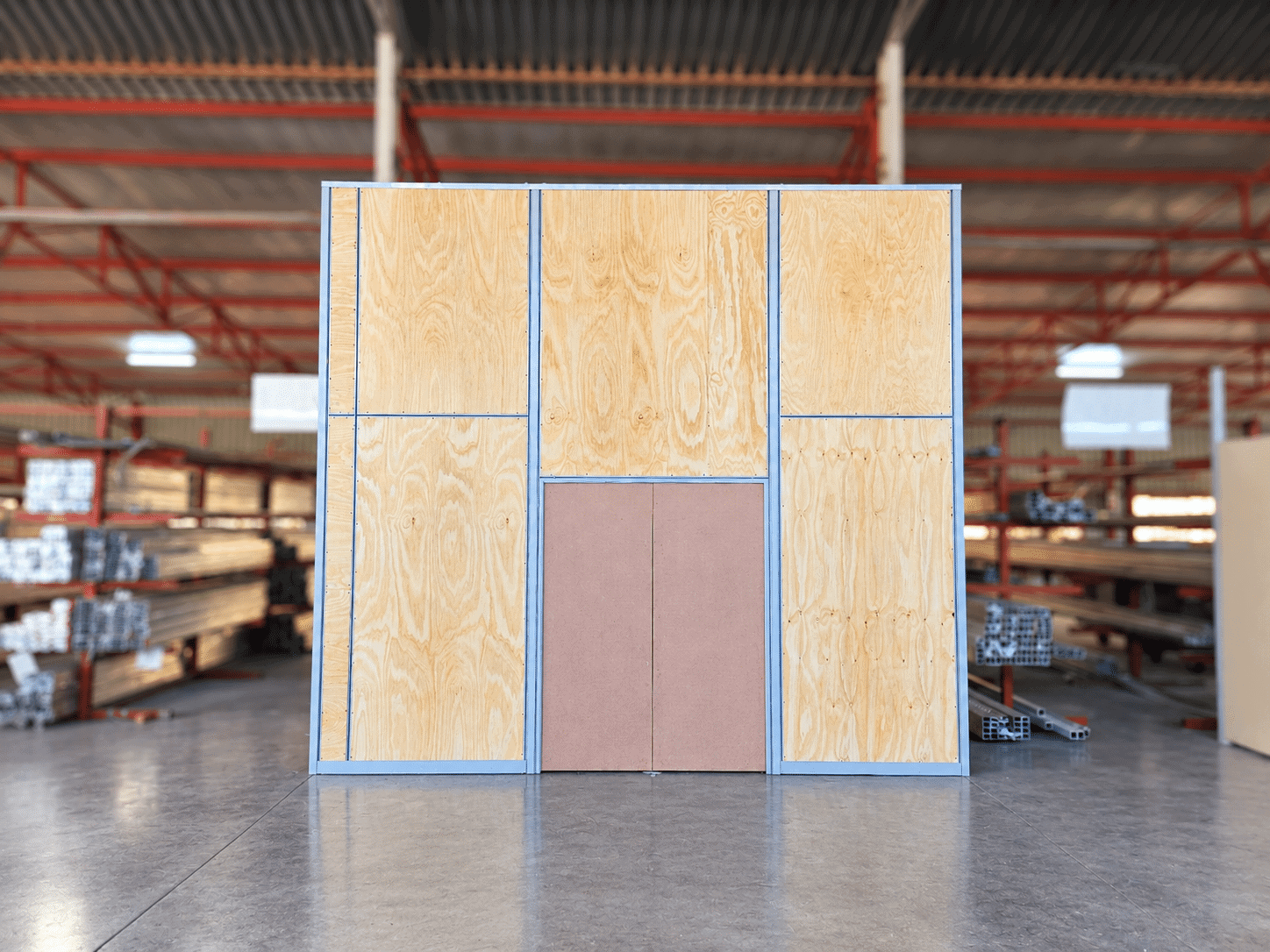 Wooden storage wall with metal framing in warehouse setting.